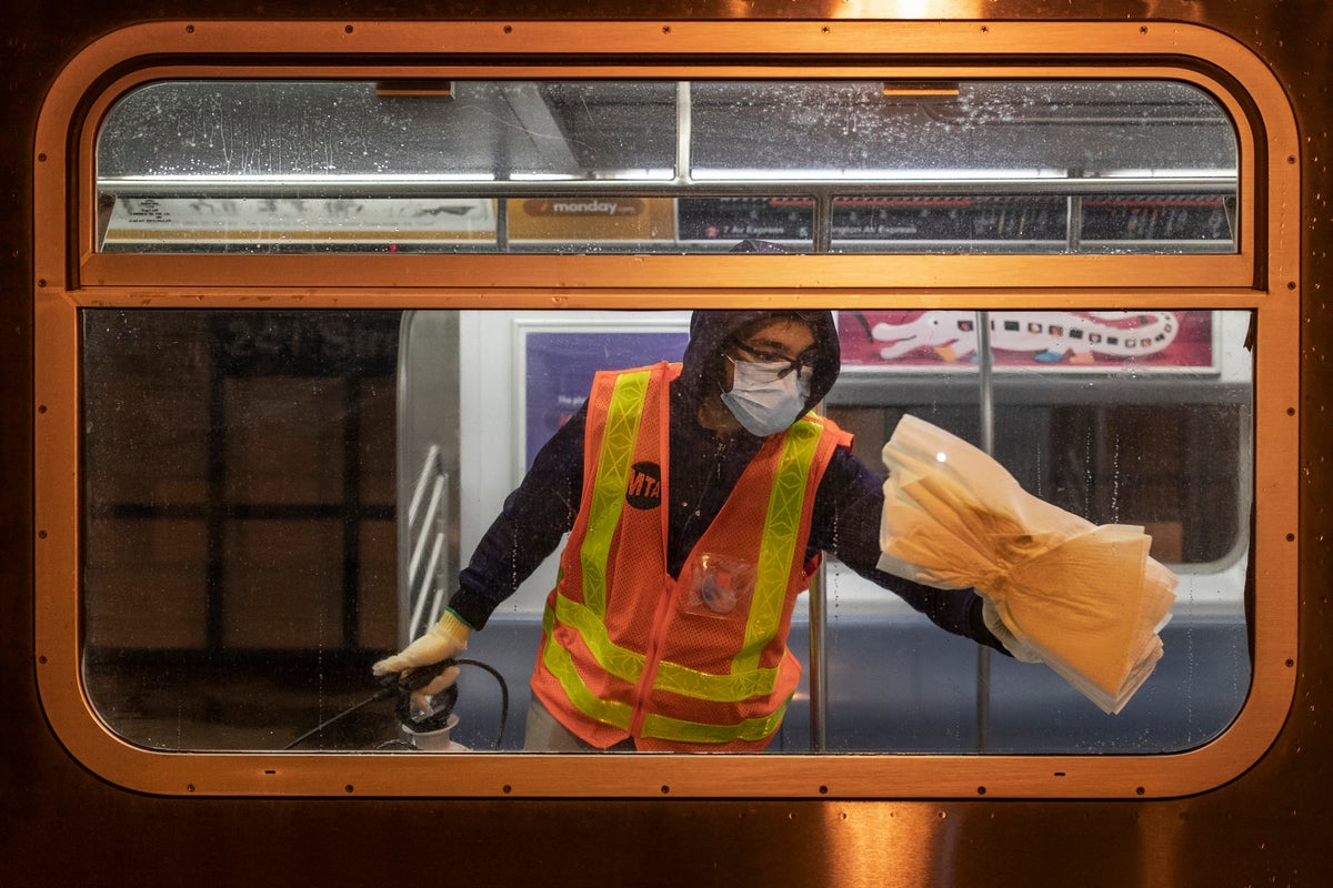 MTA worker cleaning subway windows.
