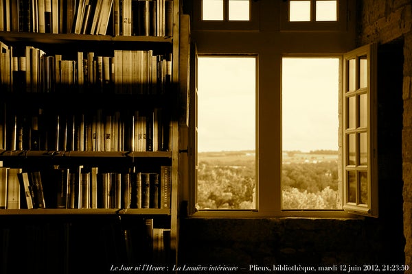 A sepia photo of bookshelves with an open window to the right