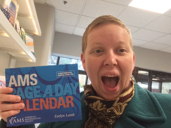 A selfie of me holding a copy of the calendar and looking excited