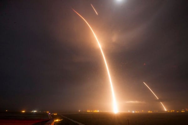 A time-lapse image of a Falcon 9 rocket launching to orbit, then returning to its launch site