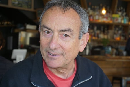 A white man in a red shirt and navy jacket