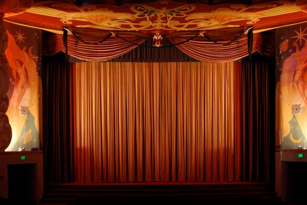 Closed red curtains at a theater