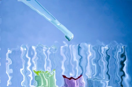Image shows a dropper putting liquid in a rack of test tubes, which are filled with various pastel-colored fluids on a blue background. The image is distorted and ripply.