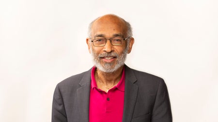 Emery N. Brown posing for a photo in a black suit jacket and pink shirt.