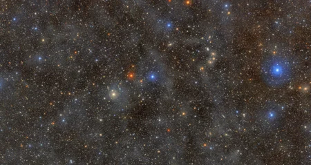 A dark sky filled with millions of pinpricks of light representing stars and galaxies.