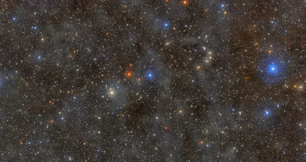 A dark sky filled with millions of pinpricks of light representing stars and galaxies.