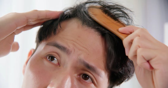 A man brushing unruly hair