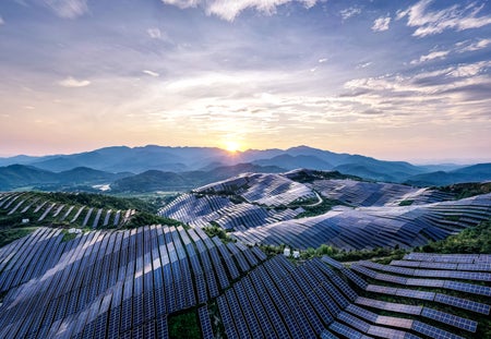 Drone point of view at the solar power station on the top of the mountain at sunset.