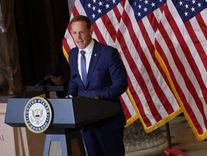 Republican U.S. senator Ted Budd of North Carolina delivers remarks from a podium, with American flags behind him.