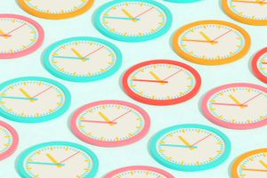 An array of colorful wall clocks viewed at a diagonal angle