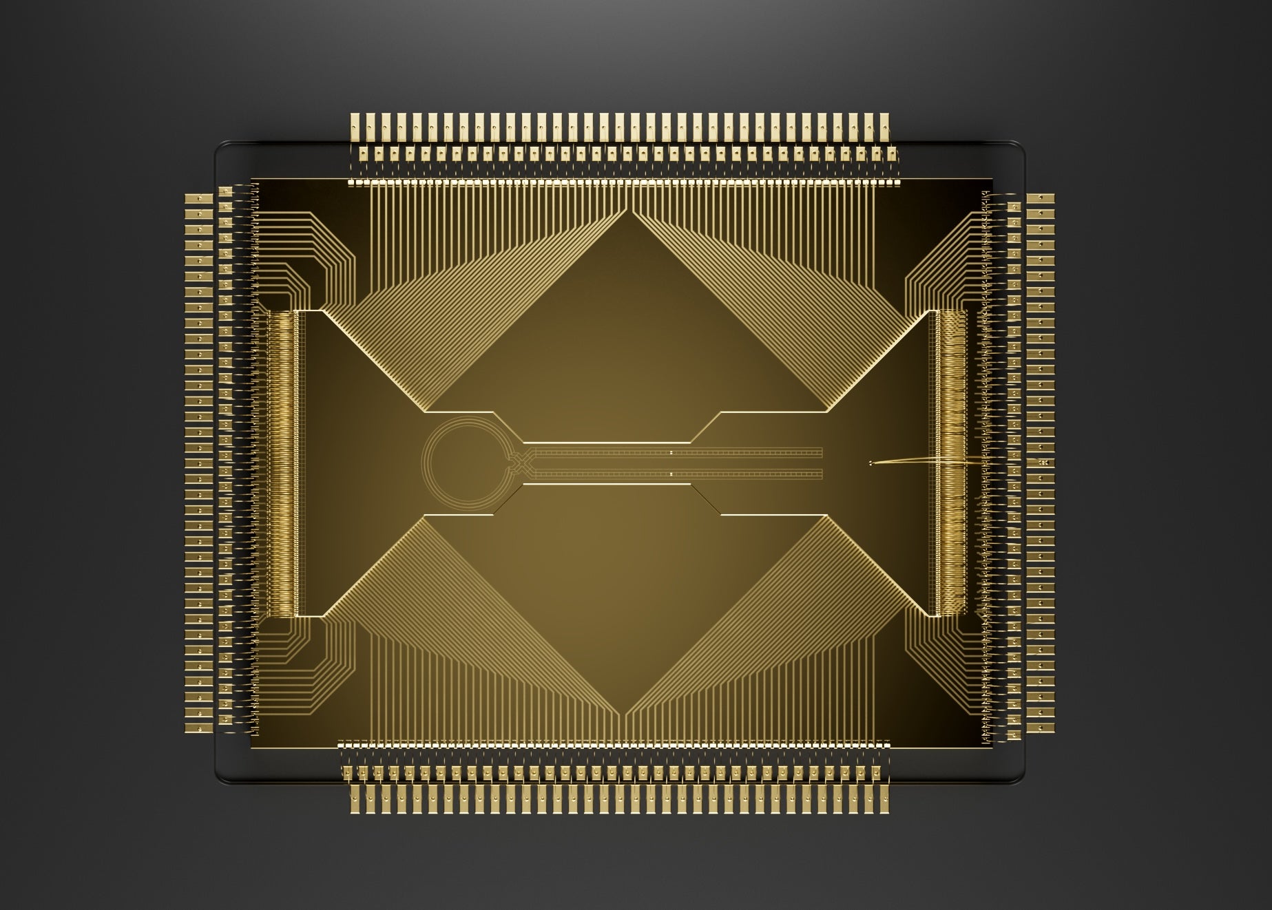 A gold square with etch marks along the edges and shapes on the top. The close-up photo shows a quantum processing chip.