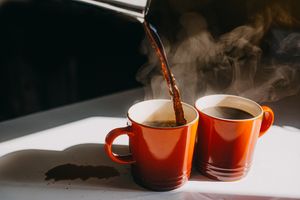 Pouring coffee into two mugs