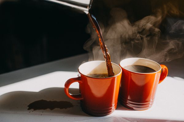 Pouring coffee into two mugs