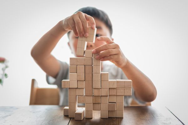 A kid playing with wooden blocks.