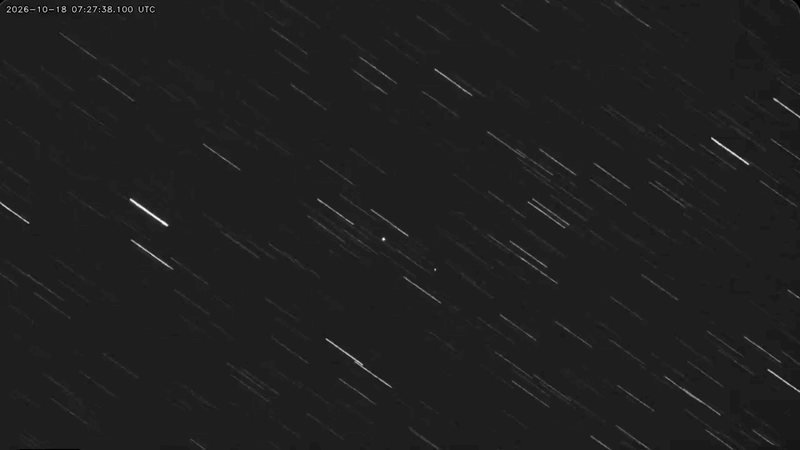Two starlike satellites move together overhead in this time-lapse image, with background stars appearing as streaks.