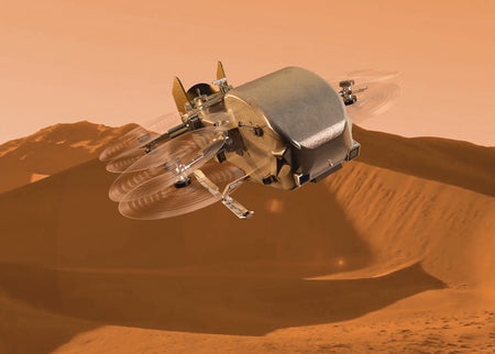 A large silvery robotic octocopter, NASA's Dragonfly drone, flies over orange dunes against a pale sky.