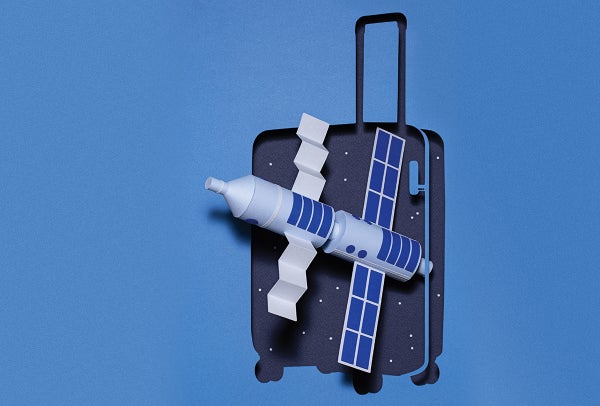 A dimensional spacecraft inside a cutout of a suitcase against a blue background.