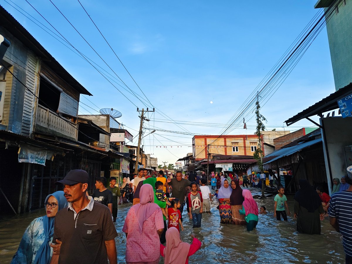 People wade through flooded streets.