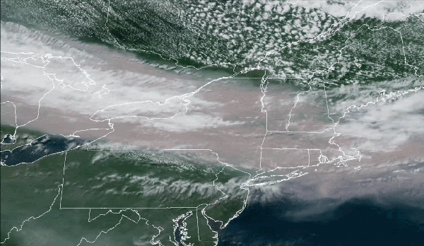A gif of a satellite image showing a river of brown smoke over the northeastern US