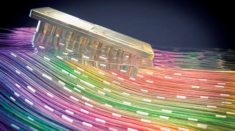 Three-dimensional rendering of a chiplike gold object floating on a series of colorful threads.