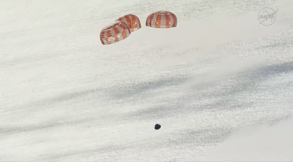 Artemis II mission capsule fallign to earth with parachutes