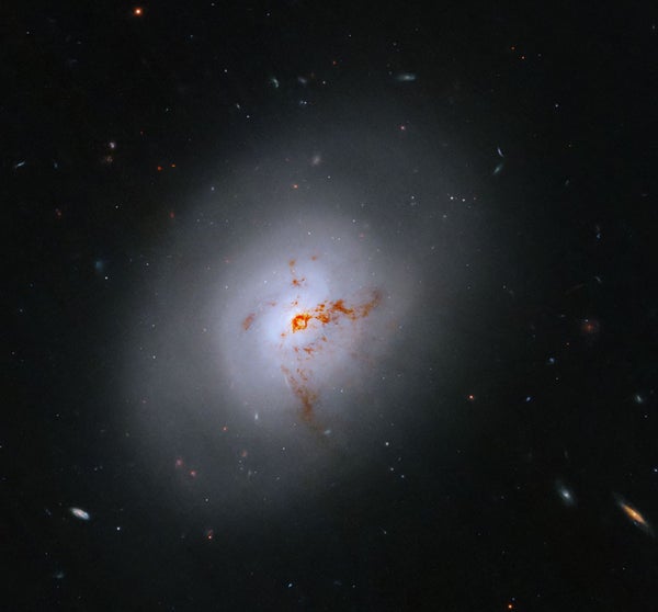This NASA Hubble Space Telescope images reveals the lenticular galaxy, NGC 1266. This enigmatic post-starburst galaxy has a bright center and a face that hints at spiral structure, yet it holds no discernable spiral arms.