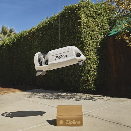 Zipline provided photo of its home delivery drone dropping a package in a residential backyard.