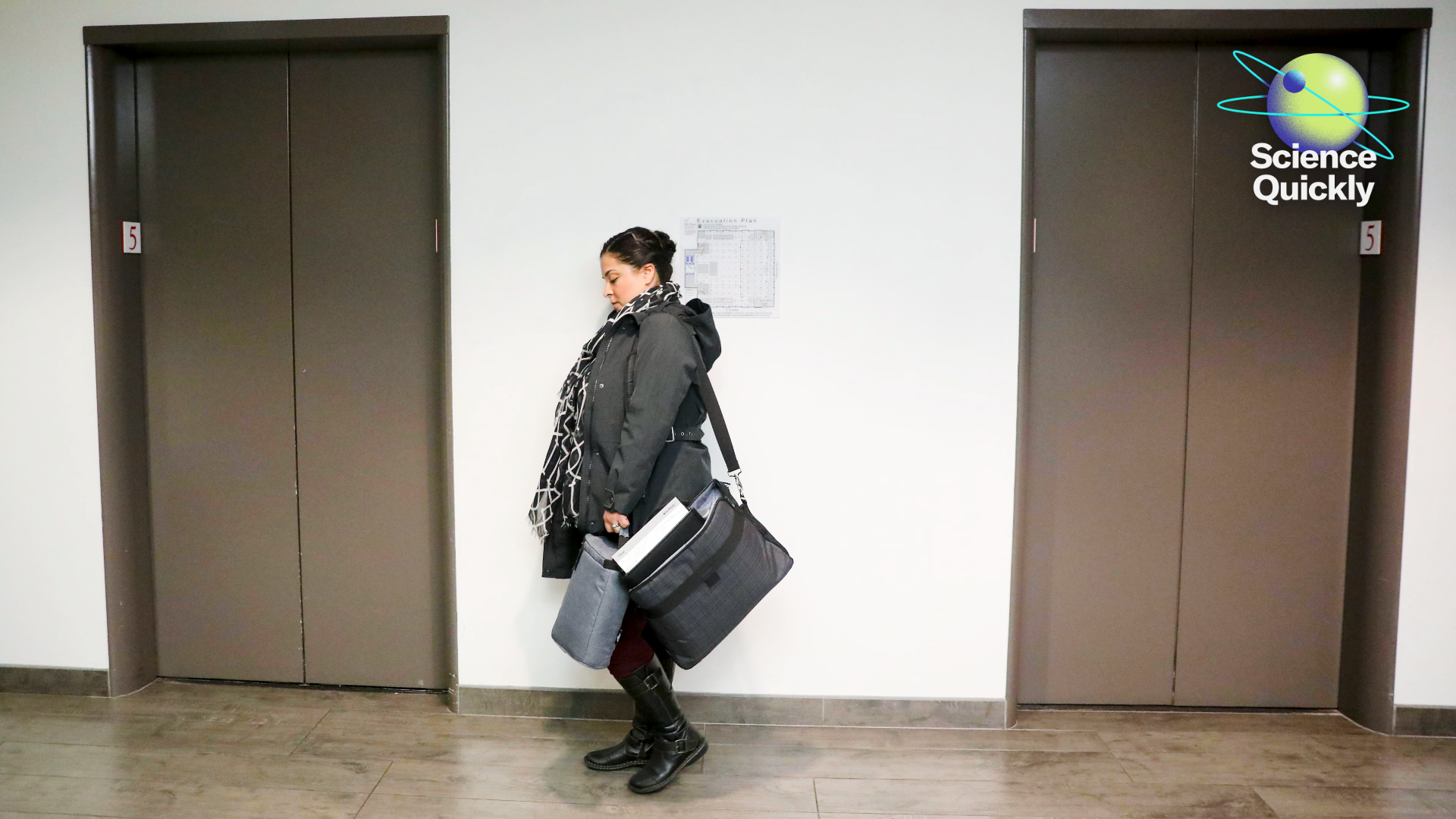 An image of a woman waiting for an elevator in a building