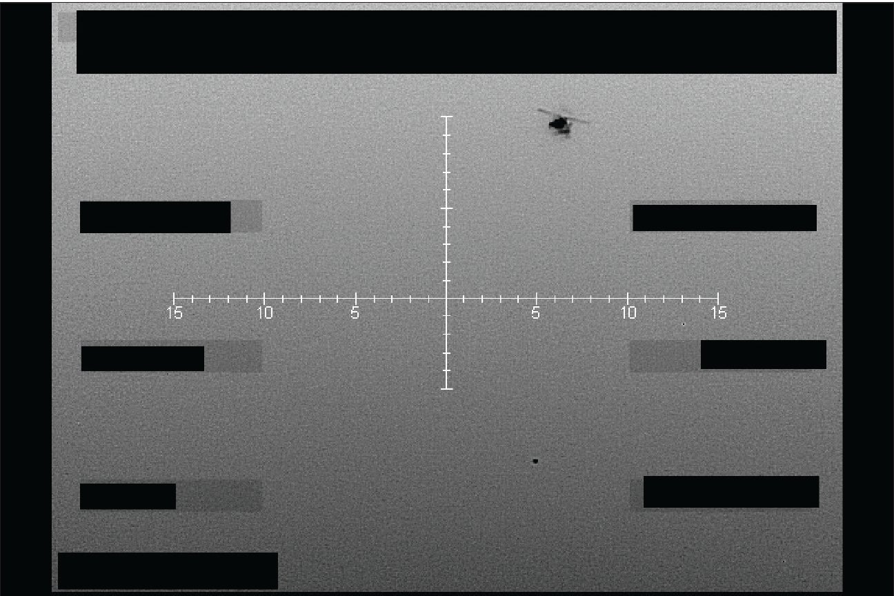Black-hot infrared photograph from above looking down at terrain with a small bright object.