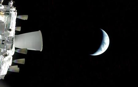 A sliver of moon behind the Orion spacecraft