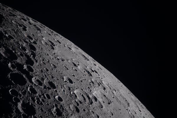 A view of the lunar surface showing craters in sharp relief.