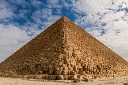 A lateral view of the Great Pyramid of Giza with detail on its weathered surface.