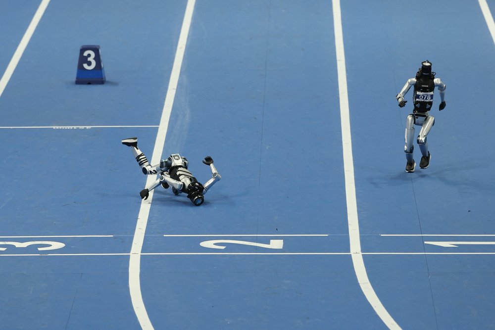 Humanoid robots race, and one falls down.