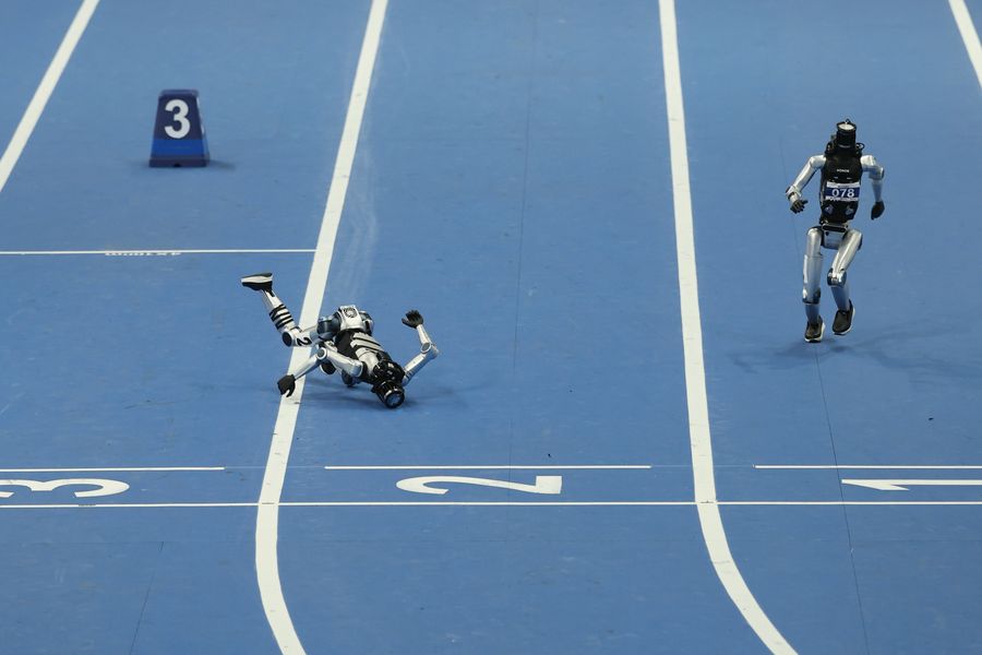 Humanoid robots race, and one falls down.