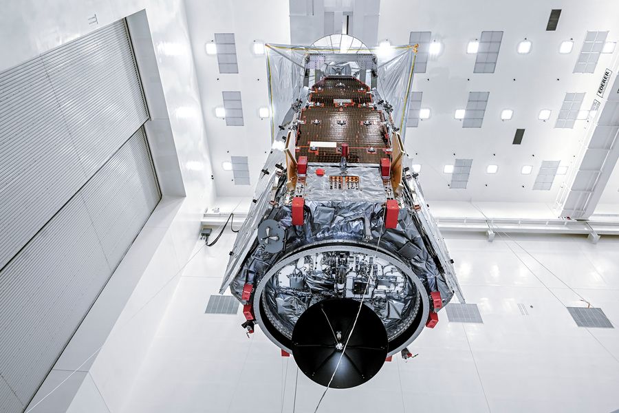 The oblong Roman telescope stands in a white clean room. Image provided by NASA/Sydney Rohde.