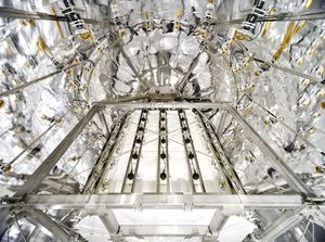 A view of the interior of a large, white tank lined with struts, wiring and sensors.