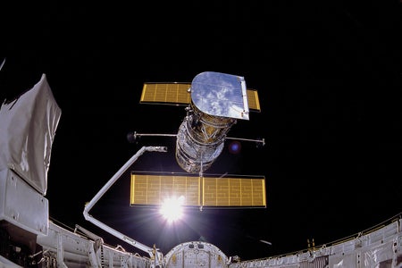 Image shows the Hubble Space Telescope being deployed.