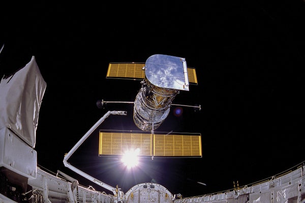 Image shows the Hubble Space Telescope being deployed.