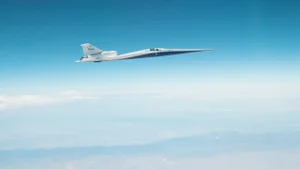 A sleek white plane speeds ahead in a blue sky.