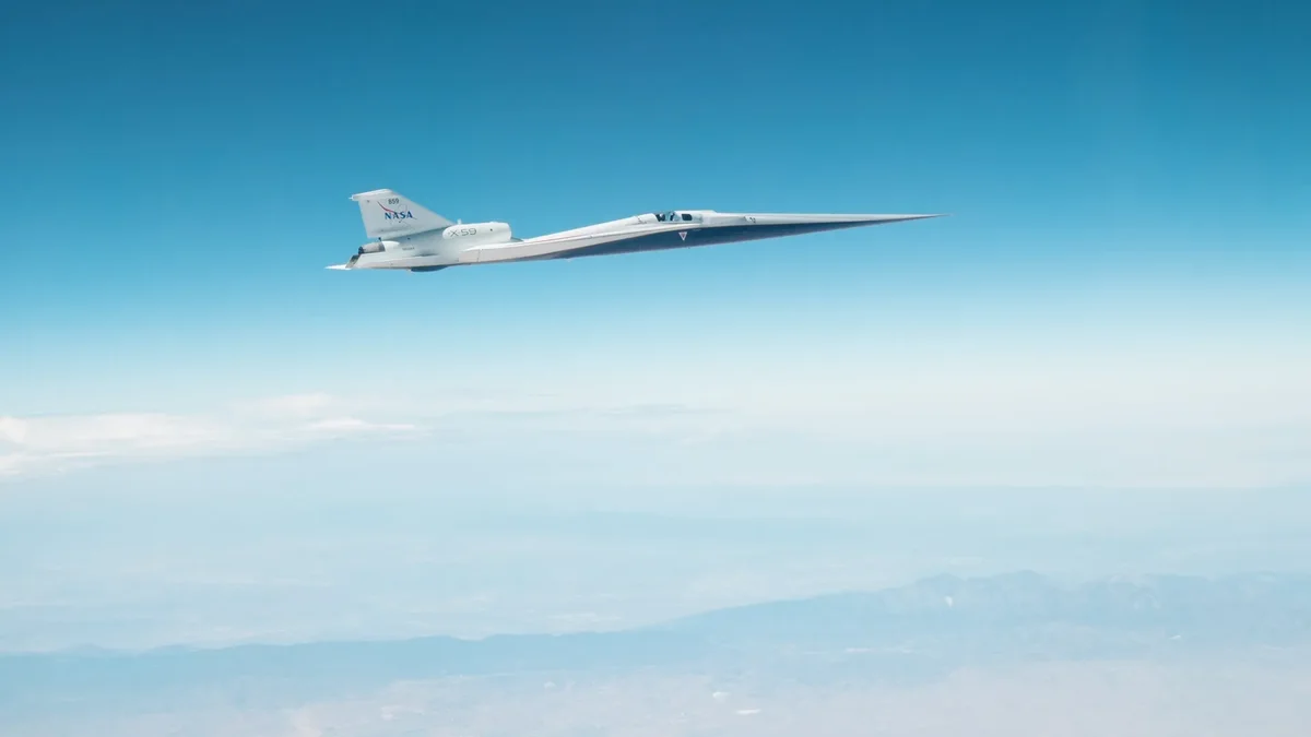 A sleek white plane speeds ahead in a blue sky.