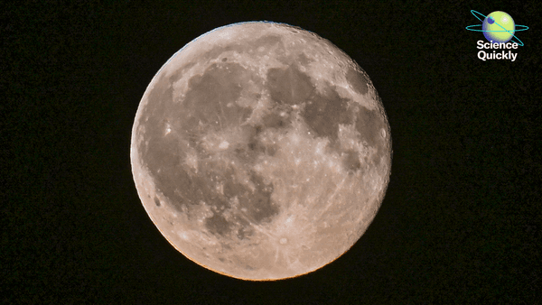 A close-up view of the gibbous moon shining brightly against a pitch-black night sky