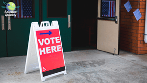 A photo of a vote here sign at an American voting location with American flags in the background