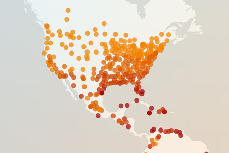 Cropped image of a world map shows North and Central America overlaid with about 250 dots in various shades of orange and red.