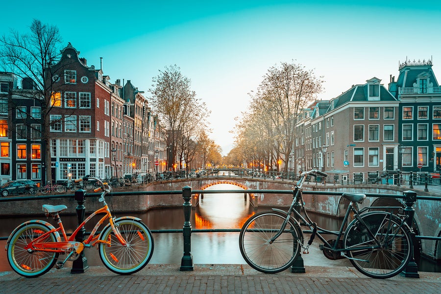 Bikes parked on the canal in Amsterdam at sunset