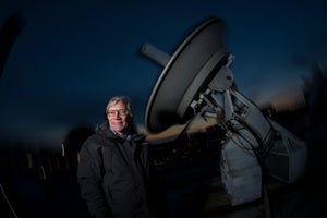 Professor Alan Guth of the Massachusetts Institute of Technology’s physics department with a radio telescope on the roof at M.I.T.