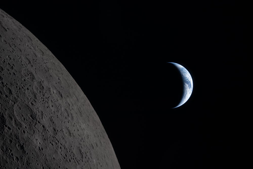 A la izquierda, la superficie gris y llena de cráteres de la luna. A la derecha, una Tierra en cuarto creciente.