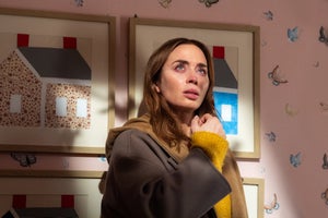 A woman who looks like she's just finished crying looks up in a child's bedroom