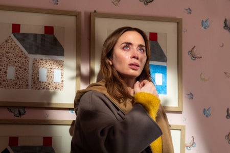 A woman who looks like she's just finished crying looks up in a child's bedroom