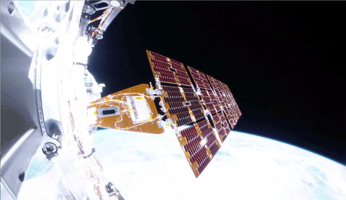 A view of a spacecraft deploying solar arrays, with Earth in the background.