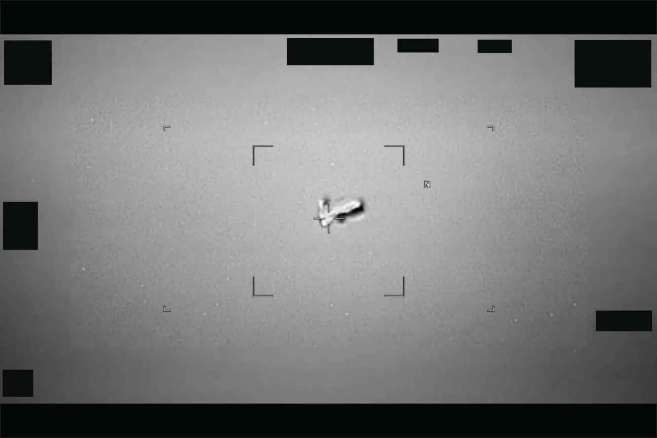 Infrared still image showing a small bright oval-shaped object against a dark sky.